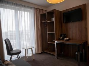 um quarto de hotel com uma secretária e uma televisão em Hotel Hague Center em Haia