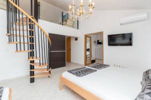 Habitación con cama, escalera y lámpara de araña. en Rooms & Apartments Hegic, en Zadar