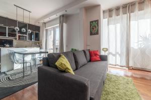 a living room with a gray couch and a kitchen at Pigneto & Malatesta Subway Flat in Rome