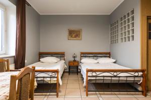 sypialnia z 2 łóżkami i stołem w obiekcie Gościniec Exclusive w Warszawie