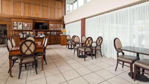 a dining room with chairs and tables and a kitchen at SureStay Plus Hotel by Best Western Brandywine Valley in Wilmington