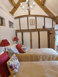 1 dormitorio con 2 camas y lámpara de araña en The Millers Cottage, en Okehampton