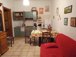 a kitchen with a table and a red couch at La Bouganville in Villasimius