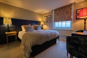 a bedroom with a large bed and a window at The Bear Esher in Esher