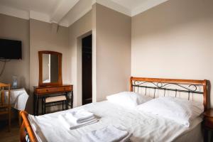 1 dormitorio con 1 cama con sábanas blancas y espejo en Gościniec Exclusive, en Varsovia