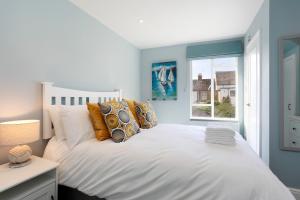 a bedroom with a white bed with a window at No 10 in Whitstable