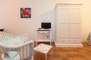 a living room with a chair and a tv at IL PORTICCIOLO in Riomaggiore