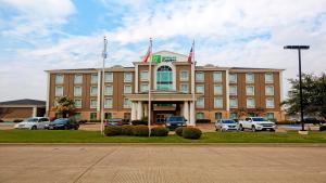 um grande edifício com carros estacionados em frente em Holiday Inn Express Hotel and Suites Corsicana I-45, an IHG Hotel em Corsicana