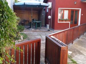 een huis met een hek en een tafel met een paraplu bij Apartman Ristic in Niška Banja