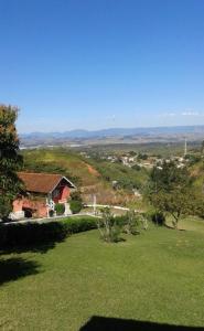 a house on a hill with a green yard at Chalé Condominio Linda Vista in Penedo