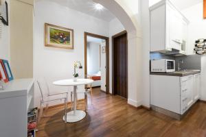 una cocina con una mesa blanca y una cocina con una habitación en Castle View - Apartment, en Verona