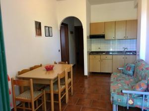a kitchen and dining room with a table and a couch at My Villa Eden in Capo Vaticano