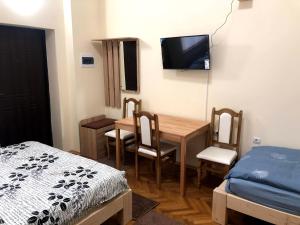 Zimmer mit einem Tisch, einem Bett und einem TV in der Unterkunft GIL apartments, Korzo 7,2 centre in Uschhorod