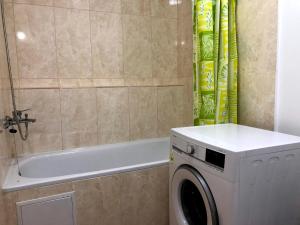 ein Badezimmer mit einer Waschmaschine und einer Badewanne in der Unterkunft GIL apartments, Korzo 7,2 centre in Uschhorod