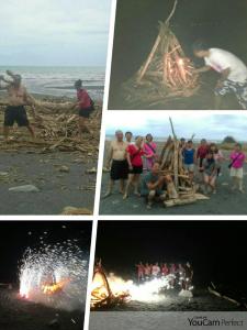 a group of people standing around a bonfire on the beach at Da Nan Ao Homestay in Suao