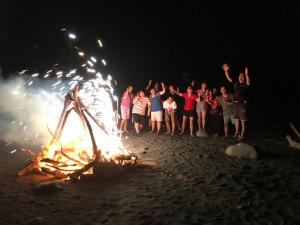 a group of people standing around a fire on the beach at Da Nan Ao Homestay in Suao