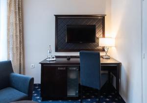 a living room with a fireplace and a chair at Hotel Kampa in Prague