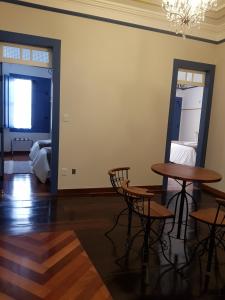 a room with two tables and chairs and a mirror at Suite Família Inconfidentes in Ouro Preto