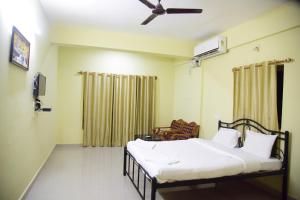 1 dormitorio con 1 cama y ventilador de techo en Homestay Siolim, en Siolim