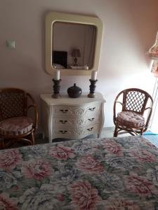 sypialnia z łóżkiem, lustrem i 2 krzesłami w obiekcie Rafina K-Apartment w mieście Rafina