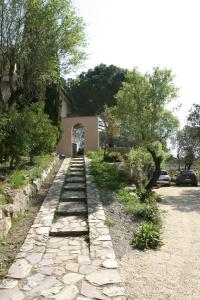 a stone pathway with trees and a building in the background at La Chiusa di Rio in Rio nellʼElba