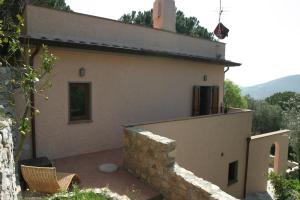 a house with a stone wall next to a building at La Chiusa di Rio in Rio nellʼElba