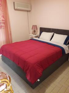 ein Schlafzimmer mit einem Bett mit einer roten Decke darauf in der Unterkunft Rafina K-Apartment in Rafina