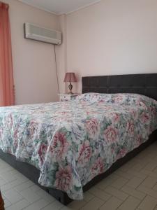 a bedroom with a bed with a floral bedspread at Rafina K-Apartment in Rafina