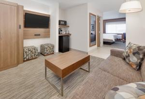 uma sala de estar com um sofá e uma televisão num quarto de hotel em Holiday Inn Express Scottsbluff - Gering, an IHG Hotel em Scottsbluff