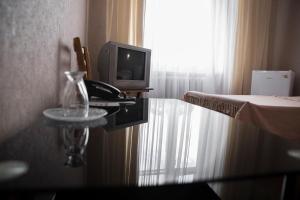 a room with a tv and a table with a telephone at Chisinau Hotel in Chişinău