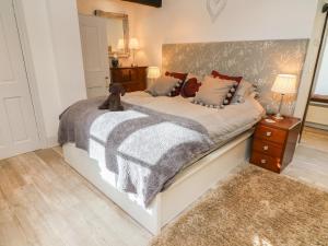 Un dormitorio con una cama grande con un osito de peluche. en Blacksmith Cottage, en Grassington