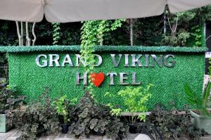 a sign for a garden viking hotel with plants at Grand Viking Hotel in Kemer