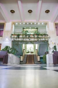an empty lobby with stairs and plants at Chisinau Hotel in Chişinău