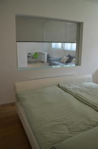 a white bed in a room with a large window at Modern und Ruhig in Wuppertal mit Heimkino-Beamer! Top Ausstattung und Privatparkplatz an der Unterkunft in Wuppertal