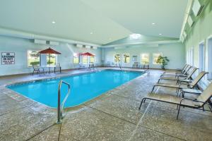 uma piscina num hotel com cadeiras e mesas em Country Inn & Suites by Radisson Benton Harbor-St Joseph MI em Benton Harbor