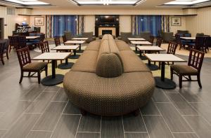 a cafeteria with tables and chairs and a couch at Holiday Inn Express & Suites Austin South-Buda by IHG in Buda