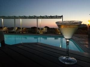 a drink sitting on a table next to a swimming pool at Aeraki Studios in Kastraki