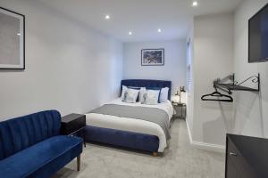 1 dormitorio con 1 cama azul y 1 sofá azul en Host & Stay - The View, Hudsons Yard House, en Whitby