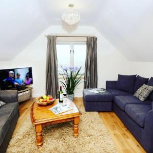 a living room with a blue couch and a table at Moorland View Lodge in Baslow