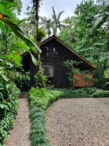 a house in the woods with a gravel driveway at Pousada do Oasis in Morretes