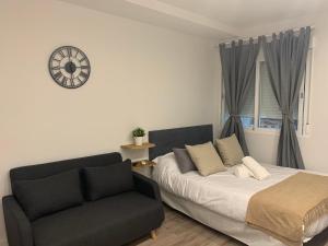 a bedroom with a bed and a couch and a clock at Lagasca Charming Apartment in Madrid