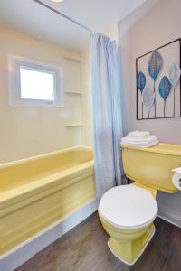 a yellow bathroom with a toilet and a tub at Motel Express in Saint-Antonin