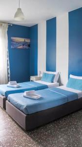 ミラノにあるアイ アム ヒア ジョイア 71の青い壁のドミトリールーム ベッド2台