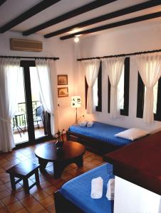 a hotel room with two beds and a table at Villa Dina in Syvota