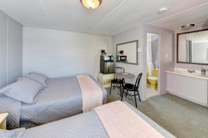Saint-AntoninにあるMotel Expressのベッドルーム1室(ベッド2台、テーブル、椅子付)