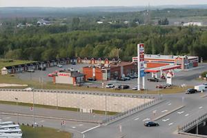 a parking lot with a gas station and a highway at Motel Express in Saint-Antonin +7 photos