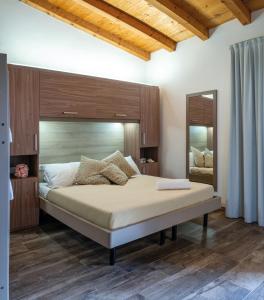 1 dormitorio con 1 cama grande y espejo en Internazionale - Family Village, en Sottomarina