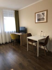 Habitación con escritorio, mesa y sillas. en Viktória Panzió, en Dunaújváros