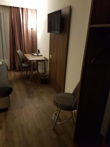 um quarto com uma mesa, cadeiras e um candeeiro em Hotel Hague Center em Haia