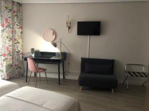 a bedroom with a desk and a chair and a mirror at Hotel Marqués de Santillana in Torrelavega